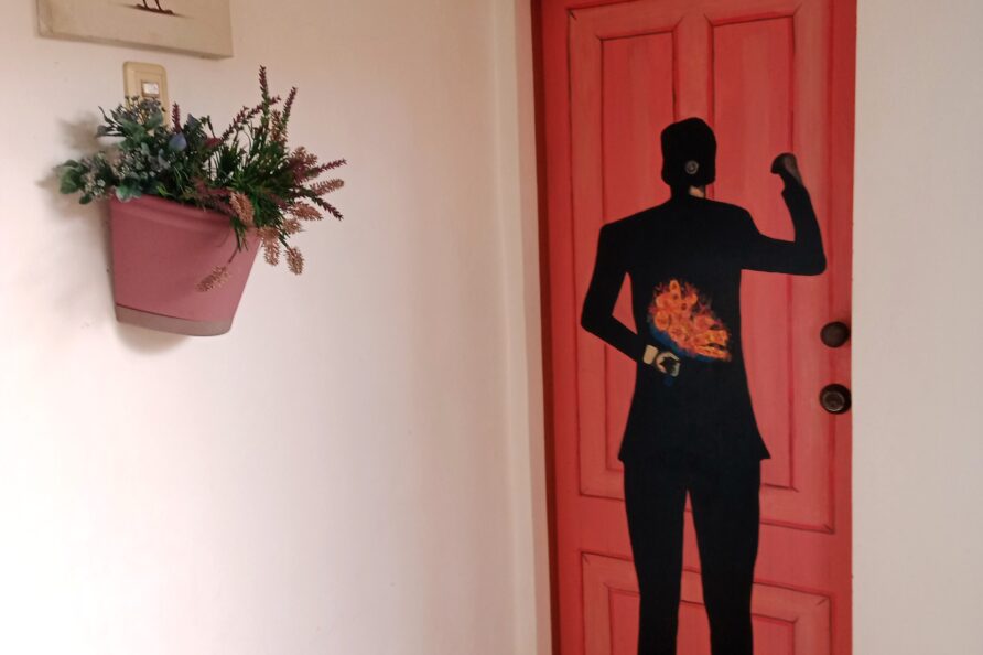 Close-up of the Couples Room's unique hand-painted door, featuring a romantic image of a man holding flowers.