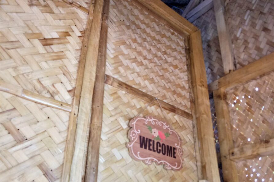 Unique entrance to the Affordable Treehouse Room San Carlos, showing the nipa door at the top of the stairs with a welcome sign.