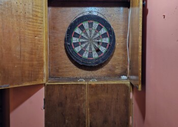 Dart board cabinet for casual group games and social activities at family reunion venue