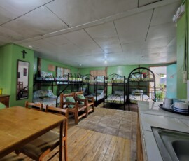 Cozy and Charming Group Accommodation: Our Family Cottages offer beautiful woodgrain accents and vibrant décor, providing comfortable and spacious sleeping quarters for your extended family reunion. Family Cottage sleeping quarters with woodgrain, vibrant paint, and colorful sheets for large group resort