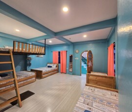 Rest in comfort and style! Casa Maria's spacious sleeping quarters feature vibrant bedding and drapes, ensuring a comfortable and cheerful stay for your entire large family reunion group. Casa Maria sleeping quarters with colorful bedding and drapes for large family reunion venue accommodation