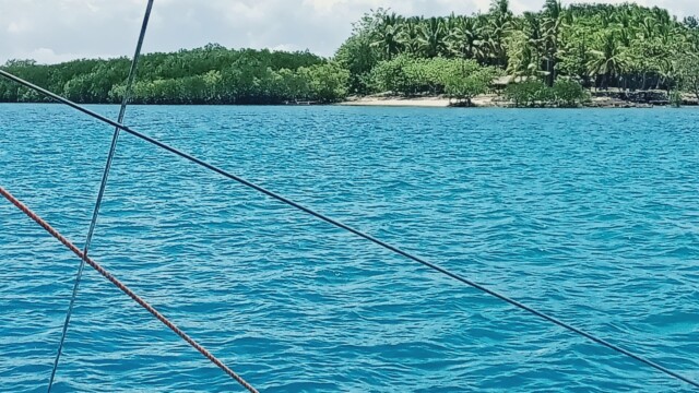 The Journey Begins: Approaching Tiningisan Island over the beautiful deep blue water. Boat approaching Tiningisan Island deep blue water